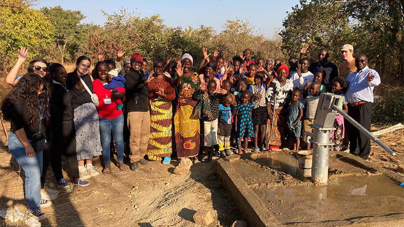 Group of people in Africa around a well provided by Foundation Outreach International